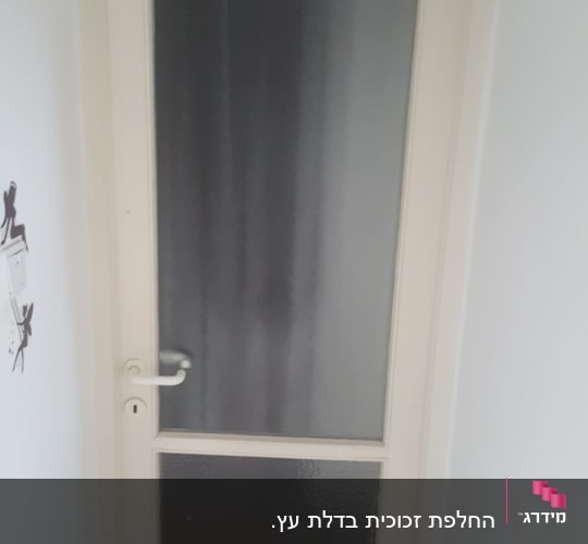 דלת עם זכוכית חלבית במרכז ובחלק התחתון